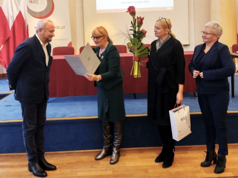 Odczytanie przez Dyrektor ORE Jadwigę Mariolę Szczypiń listu gratulacyjnego z okazji jubileuszu trzydziestopięciolecia pracy naukowej prof. Marka Konopczyńskiego. Po prawej stronie Profesora stoją Dyrektor ORE Jadwiga Mariola Szczypiń, Wicedyrektor ORE Marzenna Habib oraz Dyrektor DWKI MEN Joanna Wilewska