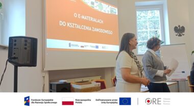 sala wykładowa, w tle ekran z napisem E-materiały do kształcenia zawodowego, na pierwszym planie dwie osoby, kierownik projektu Joanna Saska-Dymnicka oraz ekspertka projektu Beata Służalska