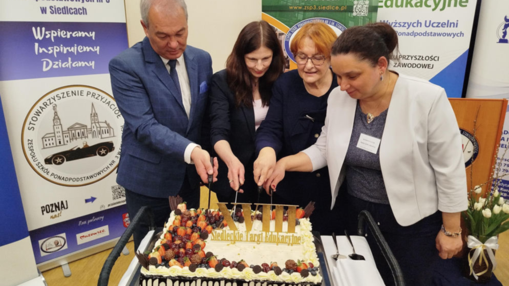 Organizatorzy wydarzenia podczas krojenia jubileuszowego tortu