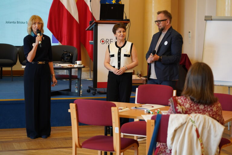 Rozpoczęcie szkolenia przez kierownik Wydziału Kompetencji Językowych i Współpracy Międzynarodowej Elżbietę Witkowską. Obok stoją współautorka nowej podstawy programowej z języków obcych Jolanta Bilska-Sulima i dyrektor ORE Mariusz Biniewski